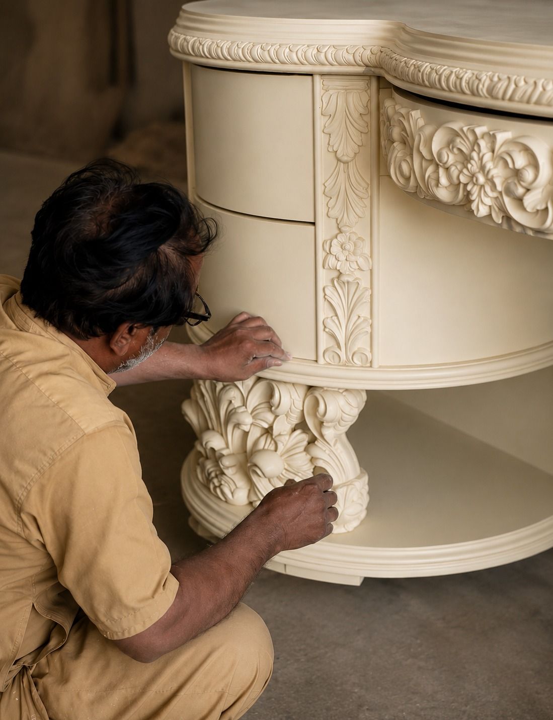 Artisan hand-finishing a carved ivory cabinet